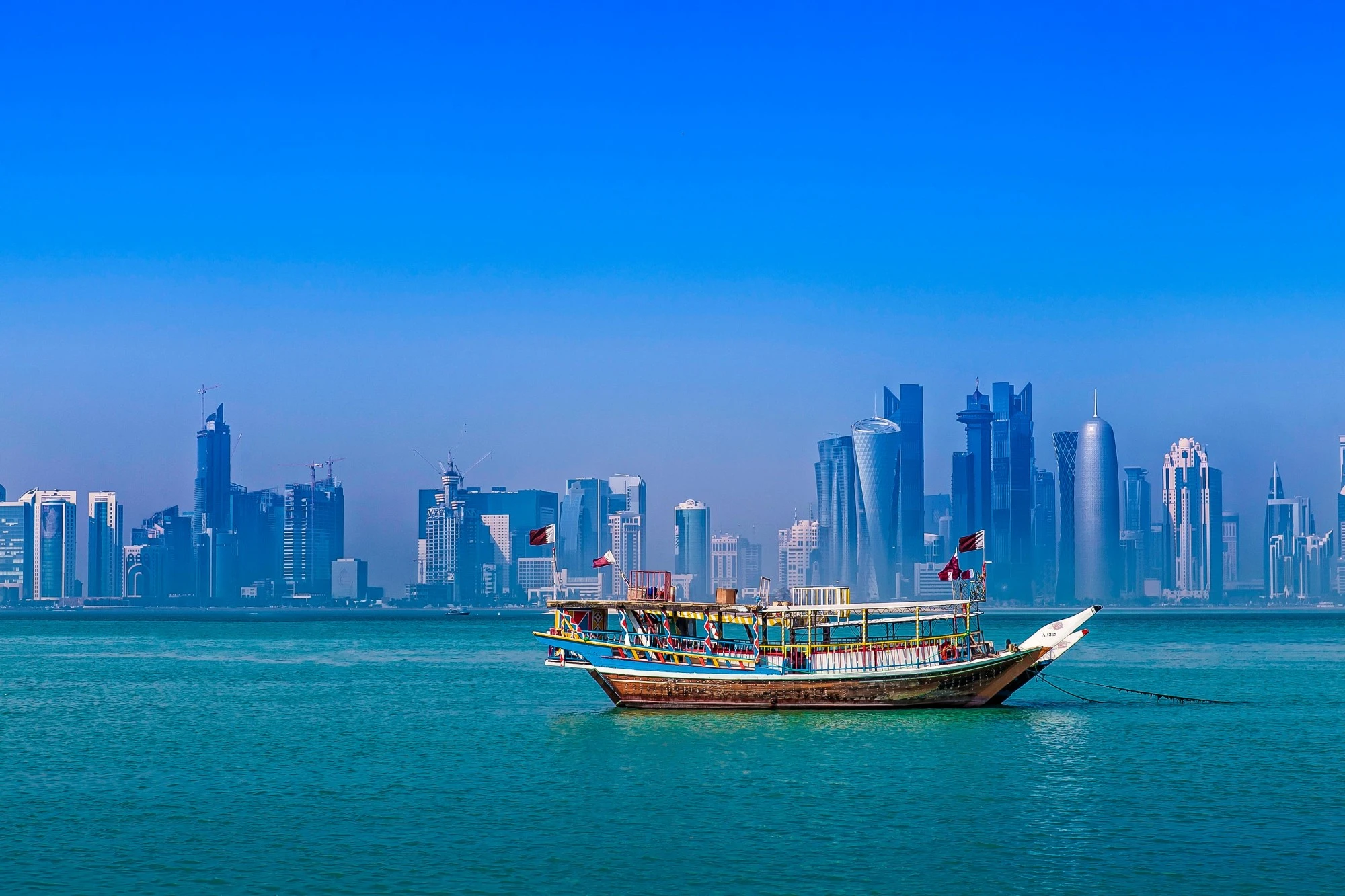 A dow sailing across the water off the coast of Doha. Pexels 