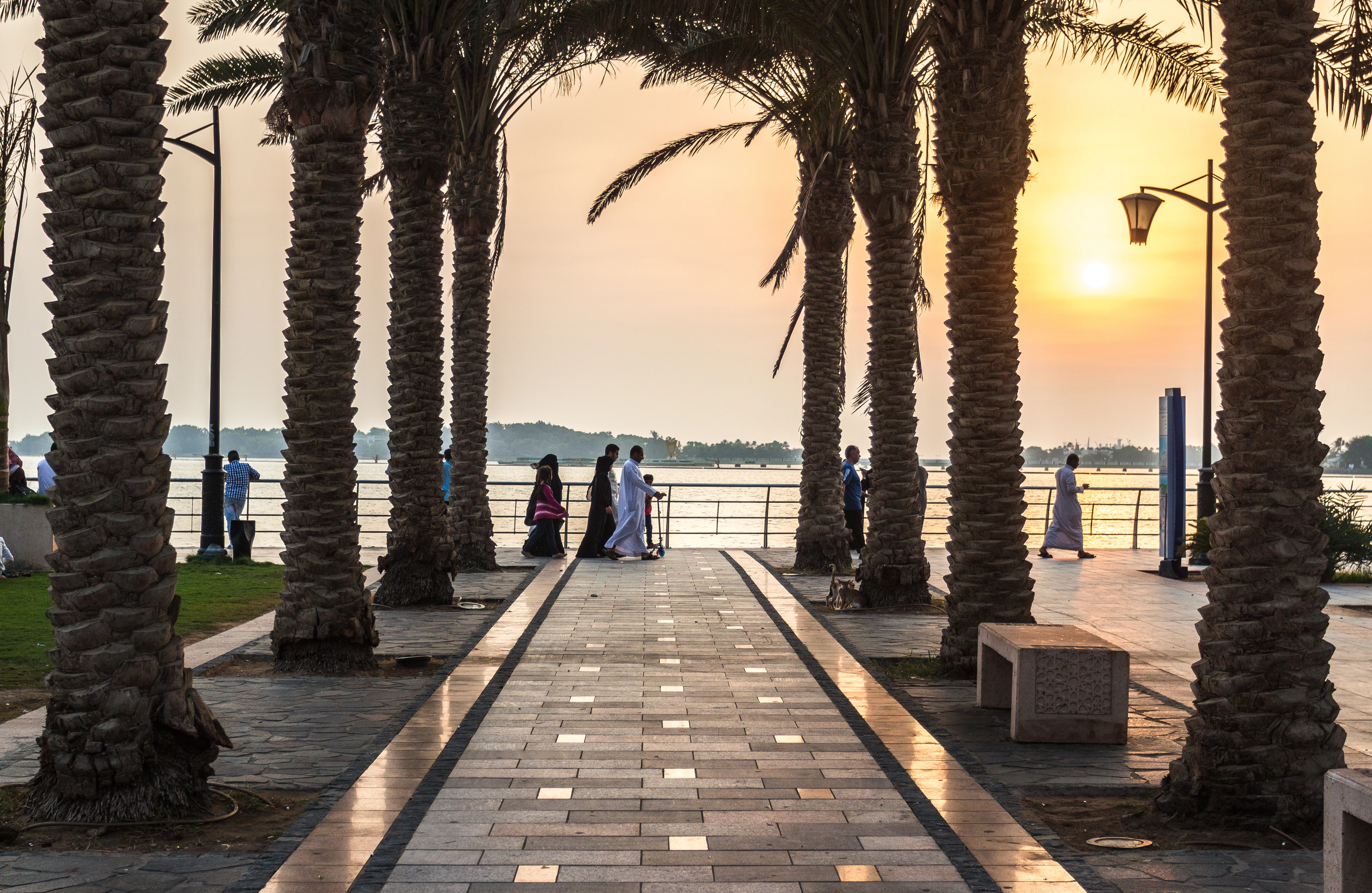 People walking along Jeddah Corniche at sunset. Shutterstock