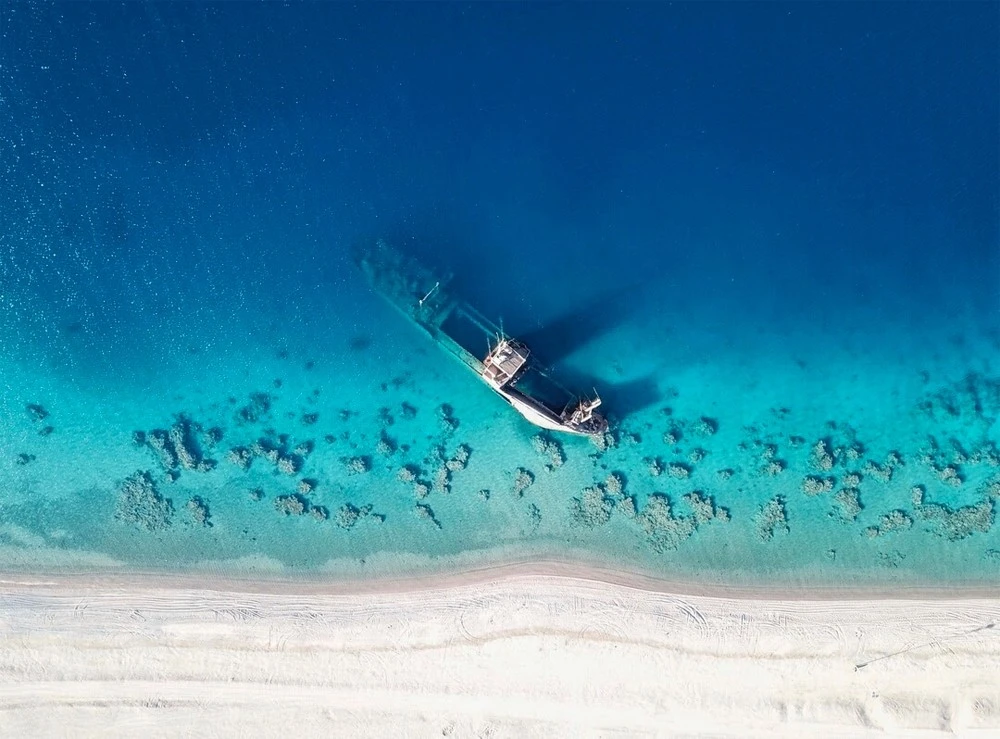 A shipwreck in shallow waters on the Haql coastline