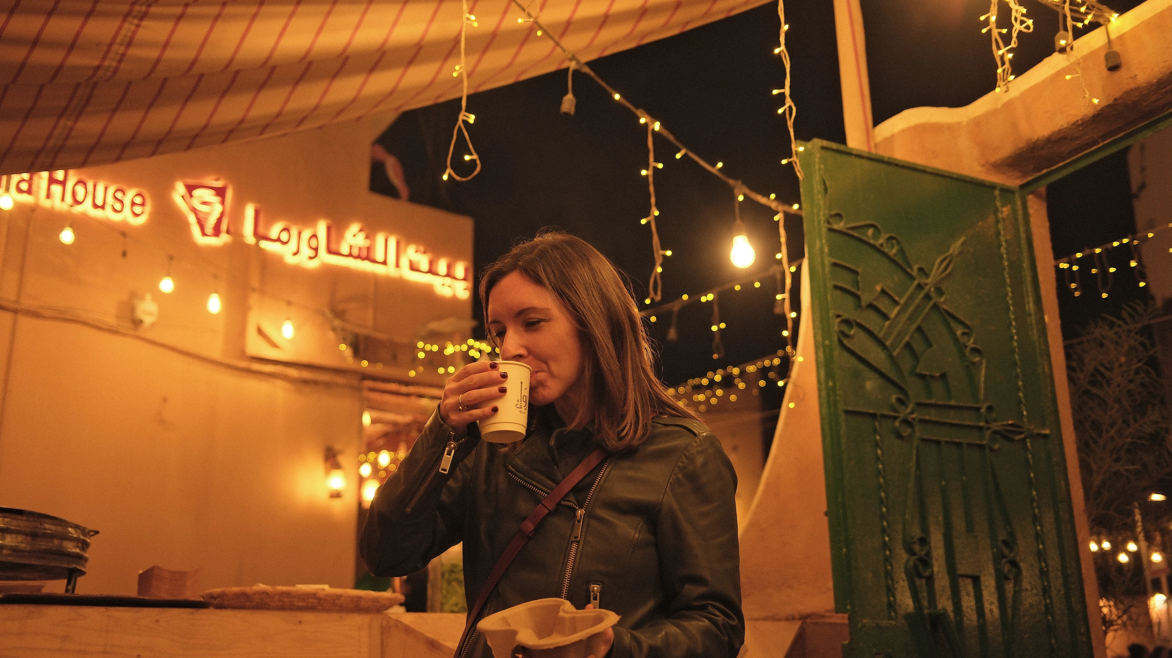 A young woman enjoying a coffee at a late-night cafe in Riyadh.