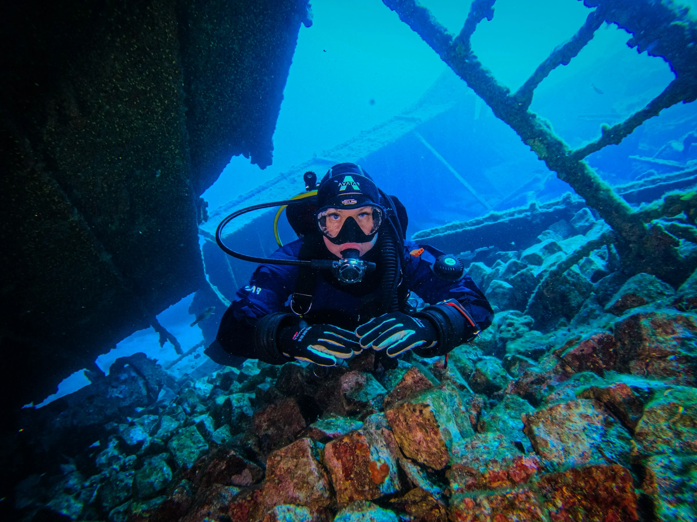 A diver passing through a shipwreck. Unsplash