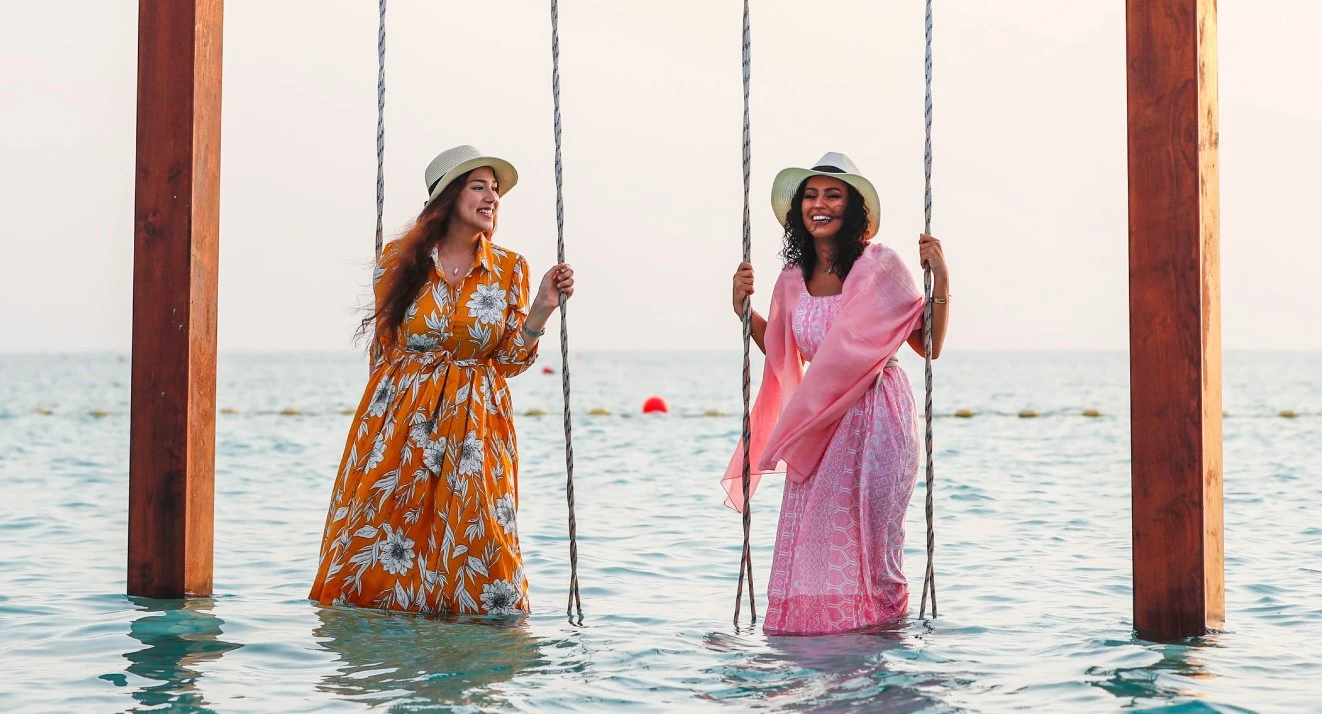 Friends enjoying a sea swing at Yam Beach in King Abdullah Economic City.