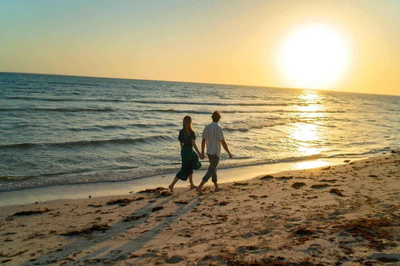 A couple strolling along a beach near Jeddah. STA